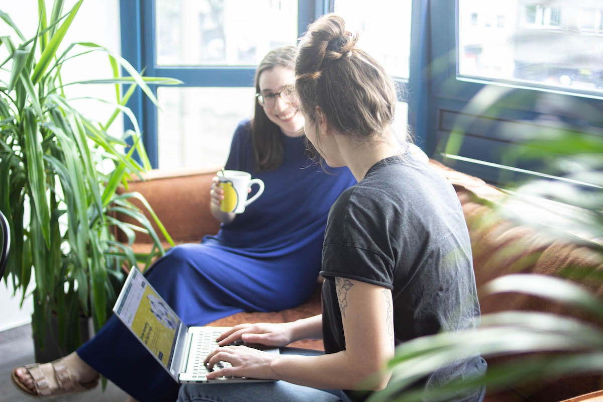 Zwei SMART LEMON Materbeiterinnen arbeiten auf dem Sofa