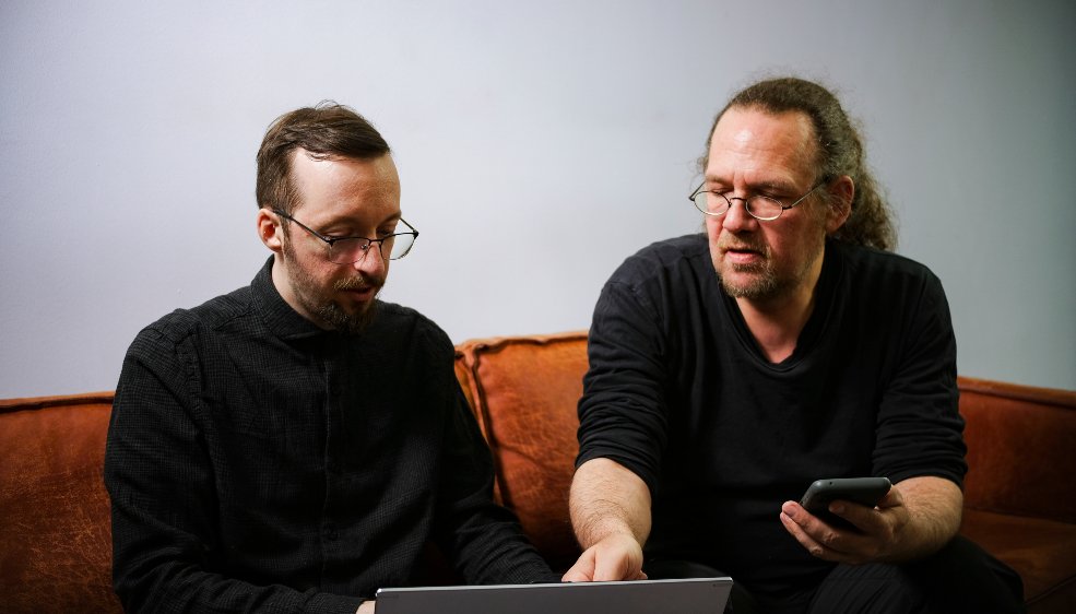 David Erdmann und Sven Giese von SMART LEMON schauen auf einen Laptop