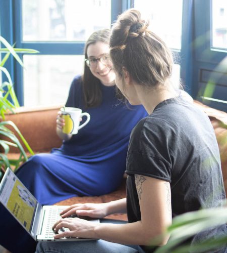 smart-lemon-agentur-koeln-so-arbeiten-wir Zwei SMART LEMON Materbeiterinnen arbeiten auf dem Sofa